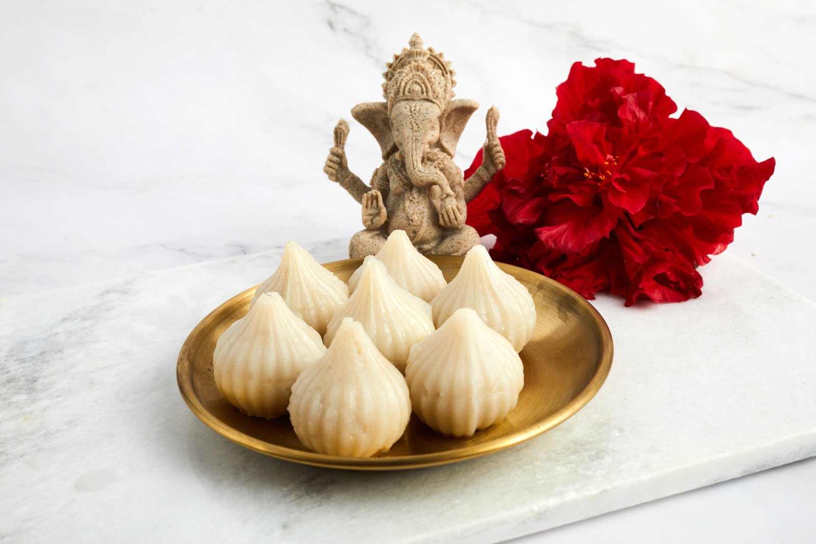 Idol of lord Ganesha with Modak Sweet Dish and flower. Ganesh chaturthi Modal Recipe