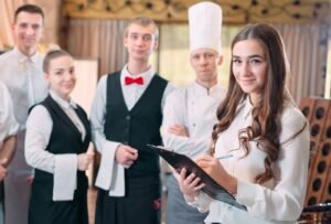 Restaurant manager, his staff kitchen interacting head chef commercial kitchen