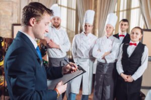 restaurant manager and his staff in kitchen. interacting to head