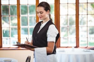 Waitress using tablet writing on a board.