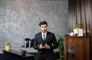 Hotel Manager in a suit using smartphone deal a customer and mana