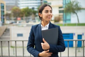 Professional girl holding file and standing out side