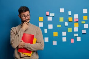 Bearded male organizing his tasks using sticky