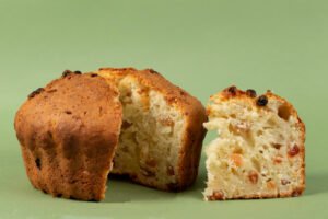 classic-cottage-cheese pie with raisins cupcake with cut piece green background