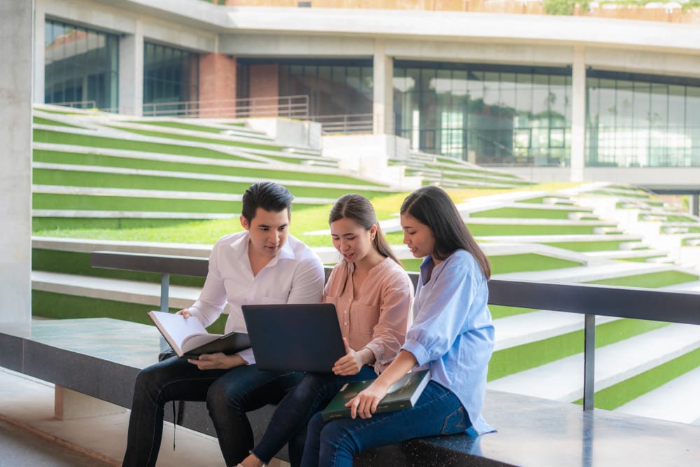 Three asian students are discussing