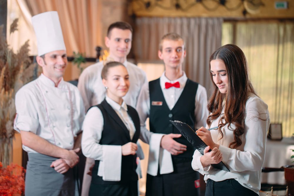 Restaurant manager and his staff in kitchen