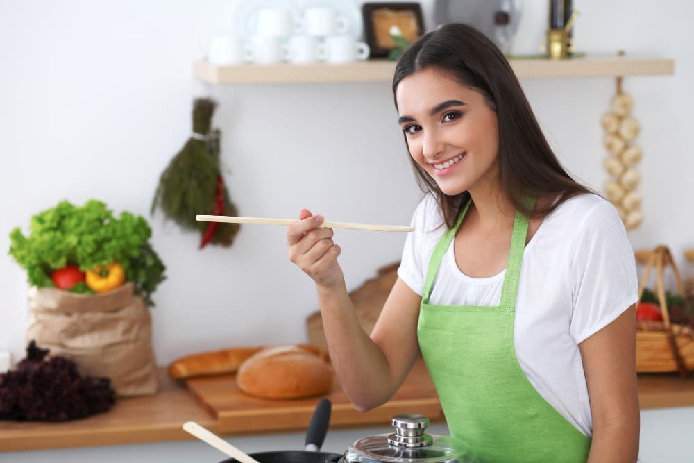 Young hispanic woman is cooking in the kitchen
