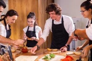 Cooking course senior male chef in cook uniform teaches
