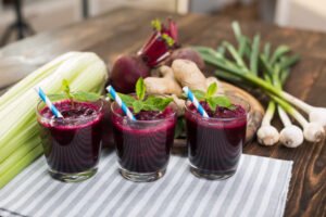 Smoothie of beets and fresh vegetables on kitchen table