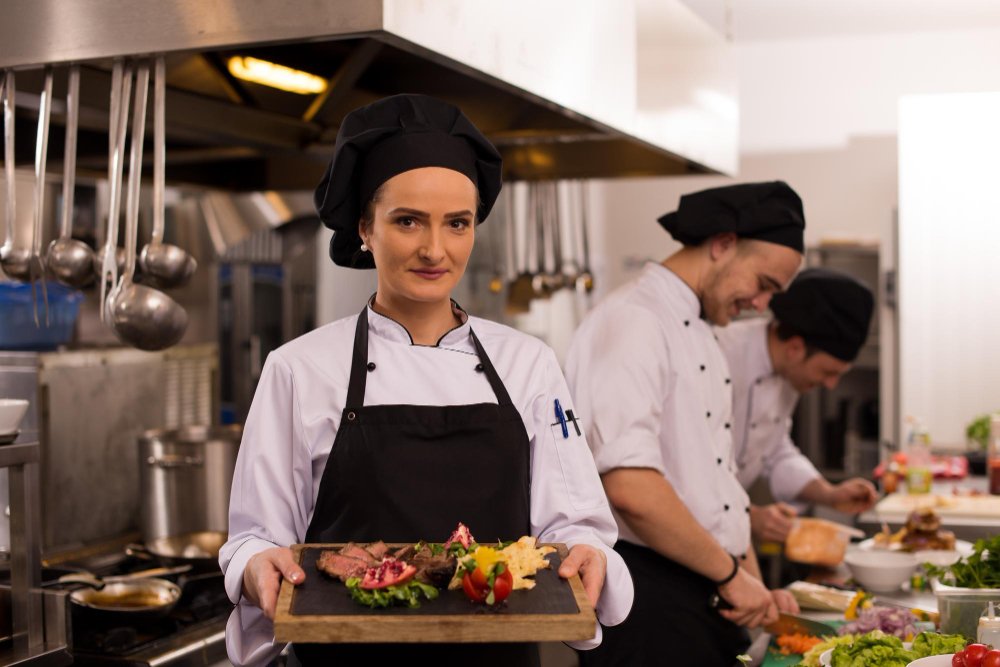 A chef in a kitchen chopping vegetables with a knife