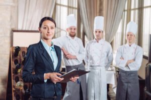 Restaurant manager and his staff in kitchen
