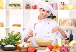 Young woman chef cooking in kitchen