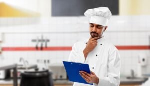 Indian chef with clipboard at restaurant kitchen