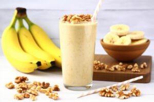 Walnut banana smoothie next to a bunch of bananas
