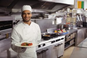 Smiling chef holding delicious dish