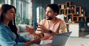 talking man woman with laptop office planning design project discussion paperwork graphic designer
